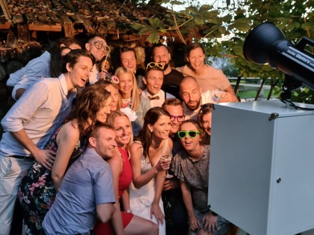 Skupina gostov se fotografira pred foto stojnico