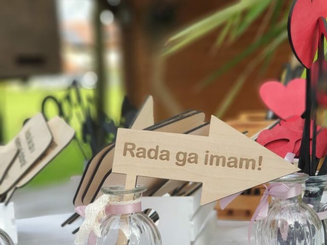 Rekviziti na mizi, lesena puščica z napisom »Rada ga imam!«