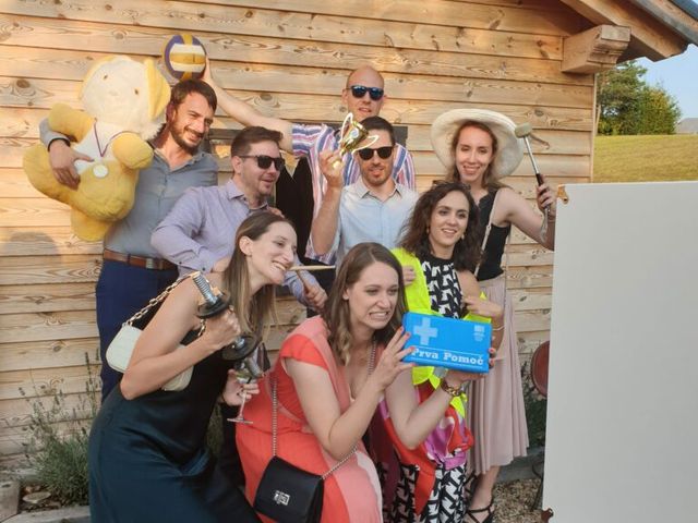 Skupina gostov z rekviziti pred leseno kočo